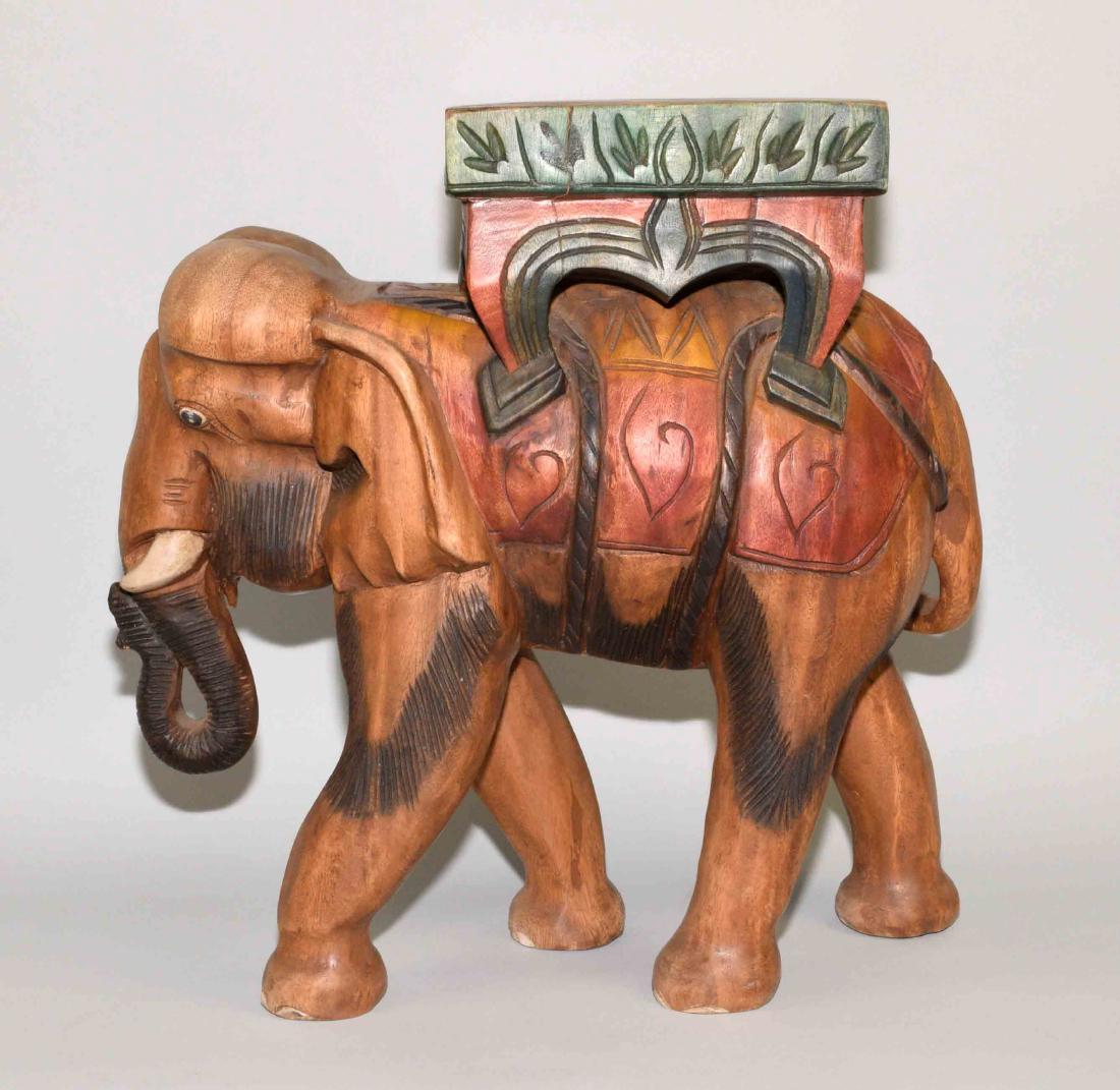 CARVED POLYCHROME ELEPHANT TABLE - Earth tone colors,: CARVED POLYCHROME ELEPHANT TABLE - Earth tone colors, tusk down, seat on back; Measures: 18.5''H x 17.5''L x 9''W - Condition: Age appropriate wear; All items sold as is.