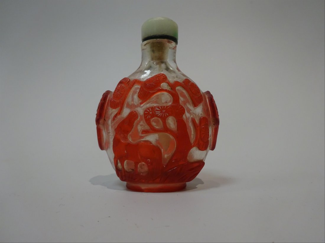FINE & ANTIQUE PINE & HORSE BEIJING GLASS SNUFF BOTTLE: A FINE AND ANTIQUE EGG-SHAPED RED-OVERLAY 'HORSE AND PINE TREE' SNUFF BOTTLE China, Qing Dynasty H (stopper excluded): 5,7 cm