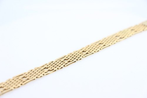 Bijoux: BRACELET plat articulÃ© en or jaune 18K (750Â°/00) Ã maillons godronnÃ©s ajourÃ©s. Fermoir Ã cliquet. Longueur : 20 cm- Largeur : 1,5 cm Poids brut : 38.1 g