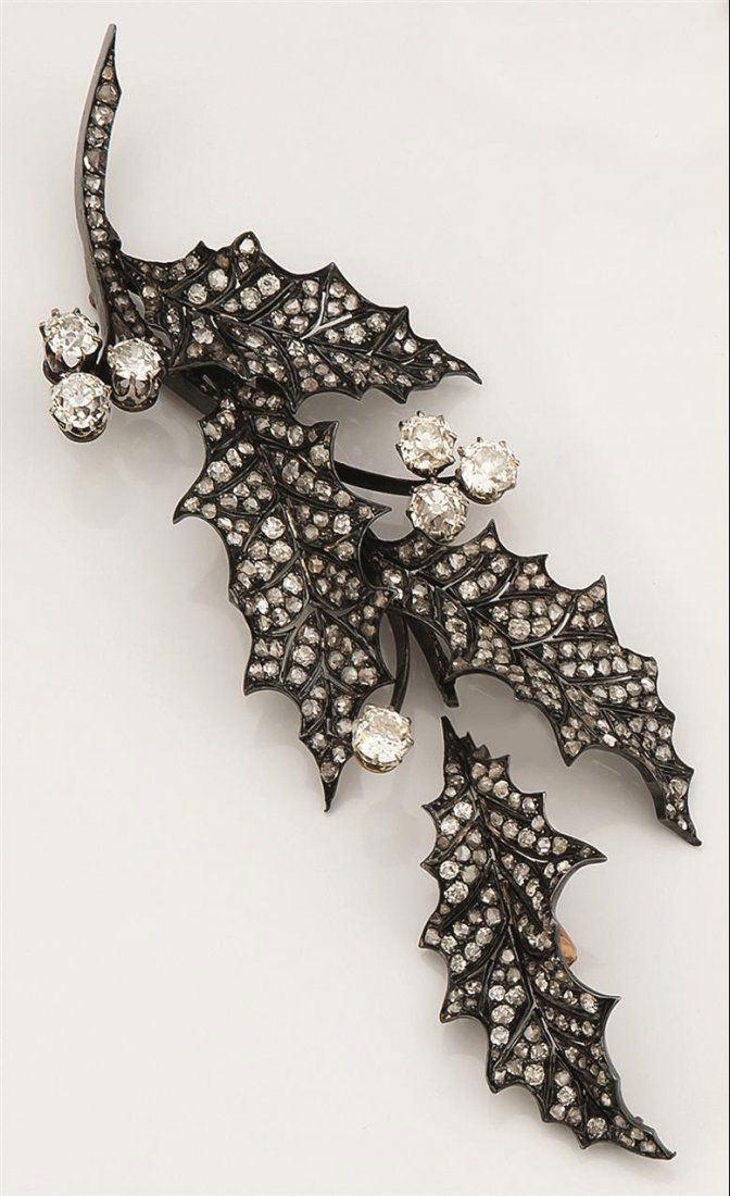 Bijoux: BROCHE en argent et or jaune formant une branche de houx transformable avec un Ã©lÃ©ment formant une feuille pouvant Ãªtre rajoutÃ©. Le tout serti de diamants taille rose et de sept diamants t