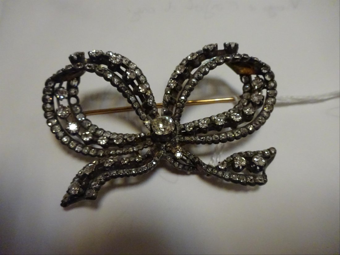 Bijoux: BROCHE noeud ajourÃ©, en or 18K (750%o) et argent (925%o) sertie de diamants de taille rose, de taille ancienne, et taillÃ©s en cousin ancien. Fin XIXe siÃ¨cle Dim. 6 x 5,5 cm Poids brut : 26.11