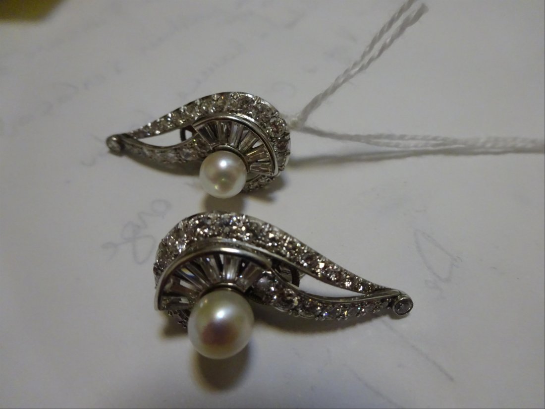 Bijoux: Paire de BOUCLES D'OREILLES formant des volutes en or blanc 14K (585%o) serties de diamants ronds taillÃ©s en brillant, en baguette, et de perles de culture. Travail Ã©tranger. AnnÃ©es 50 SystÃ