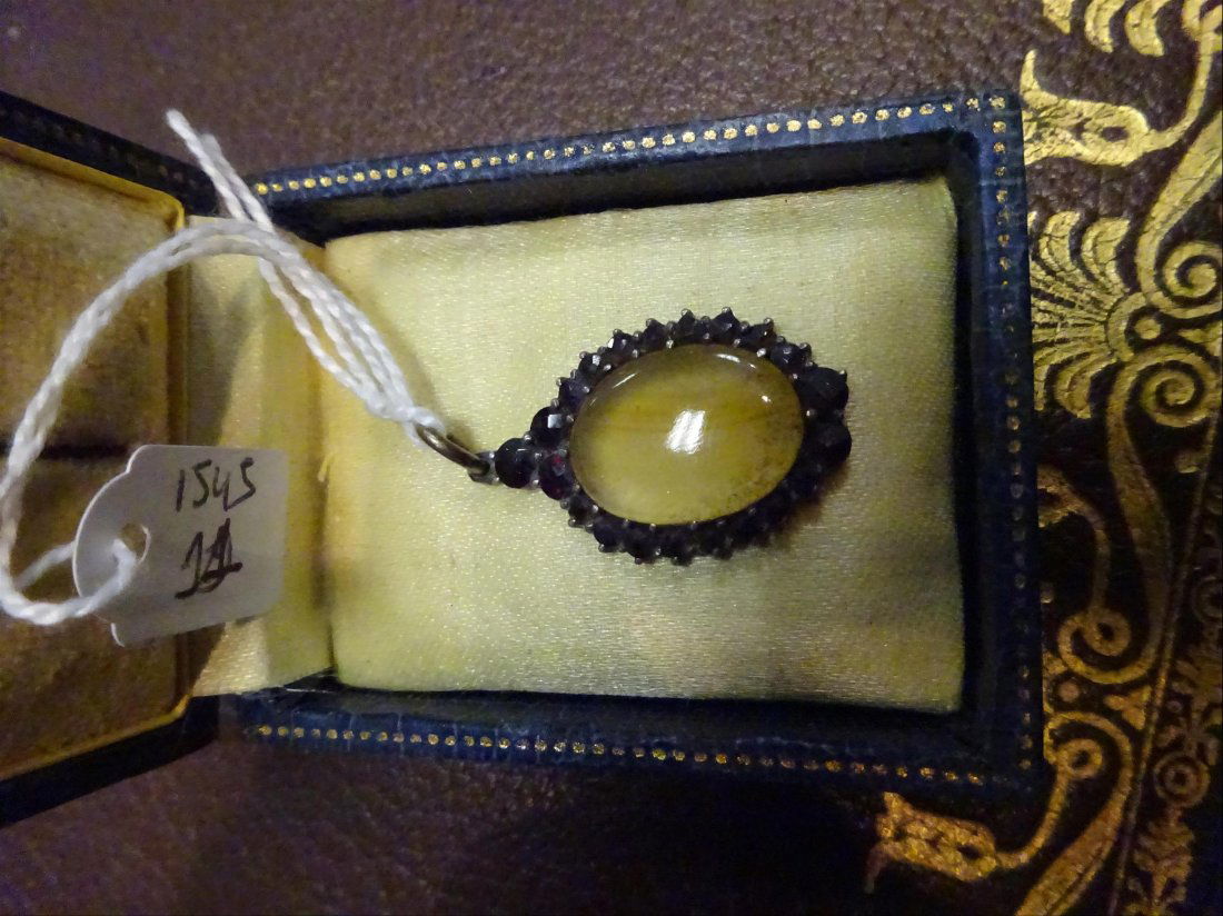 Bijoux: PENDENTIF en argent (800Â°/00) ornÃ© d'un cabochon d'agate lui-mÃªme entourÃ© de grenats taillÃ©s en brillants. Travail probablement anglais. XIXÃ¨me siÃ¨cle Poids brut : 3.52 g