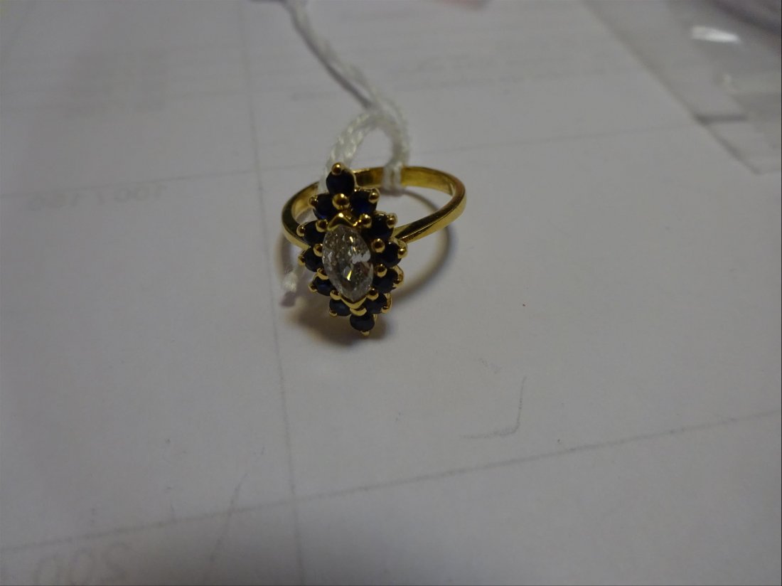 Bijoux: BAGUE " marquise " en or jaune 18k (750Â°/00) sertie d'un diamant taille navette, env. 0,3 ct, entourÃ© de saphirs ronds. Tour de doigt : 51 Poids brut : 3,5 g