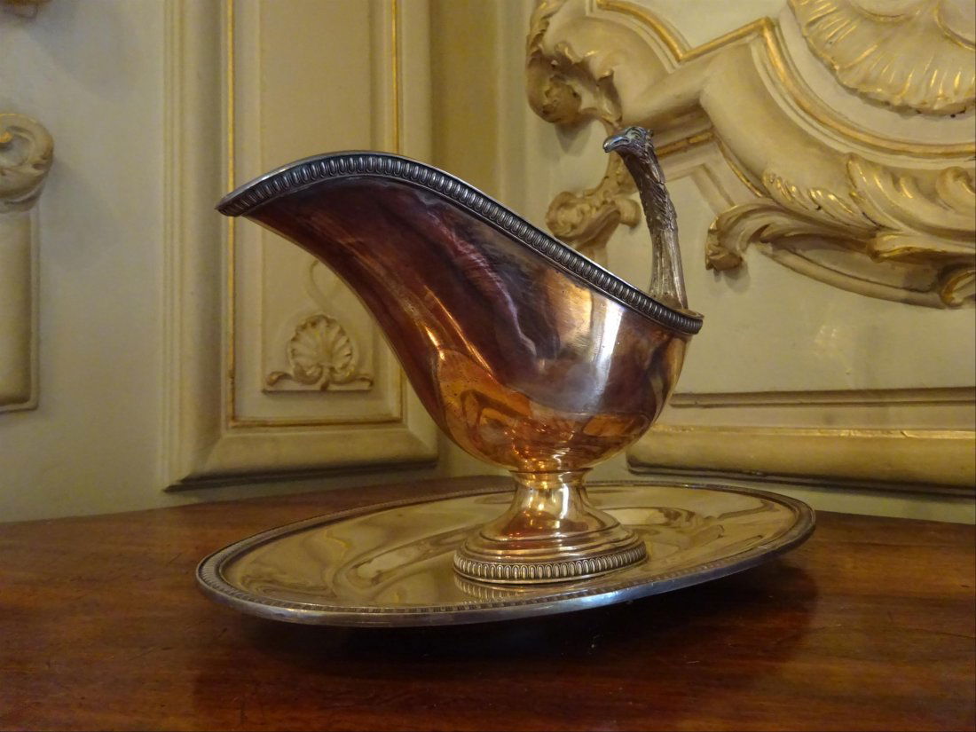 Argenterie: SAUCIERE anse en forme d'aigle en mtal argent, dcor de frises de fleurs. H : 19 cm l: 26 cm