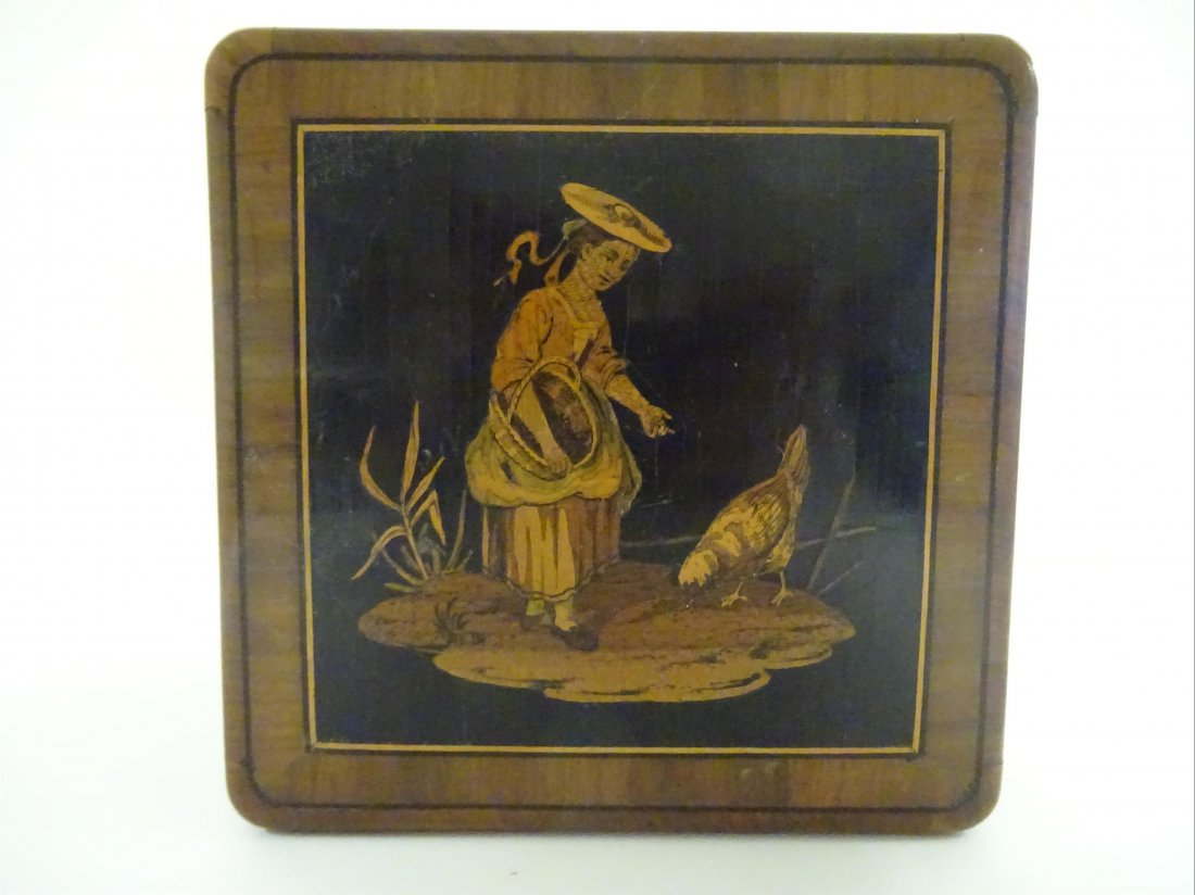 Rgionalisme: MARQUETERIE NICOISE - Bote th de section carre en olivier orne d'une nioise nourissant une poule. Etiquette l'intrieur: "Mignon Philippe Brevet FABt bois mosaque 46, Rue d'Antibes, Cannes". Circ