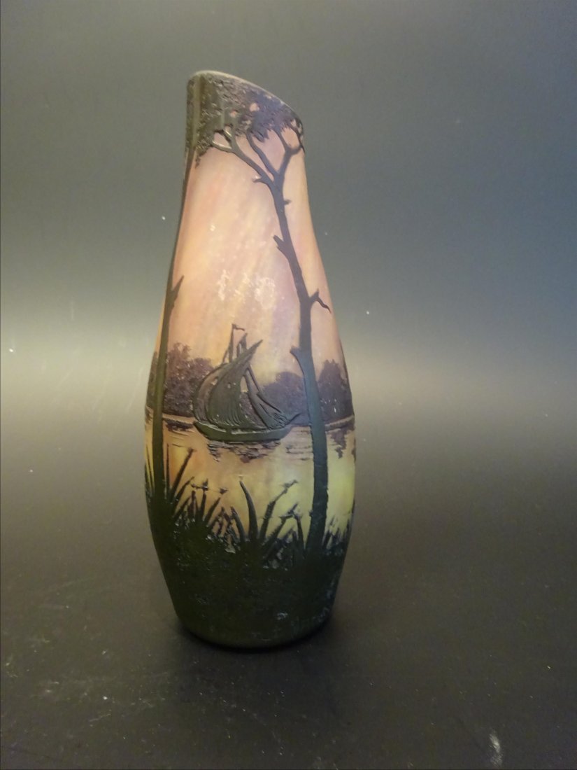 Objets d'Art: DAUM Soliflore en pte de verre violine dcor dgag l'acide de voiliers sur un fleuve. Sign et situ au bas: Daum Nancy la Croix de Lorraine (col coup et meul). H: 19,5 cm