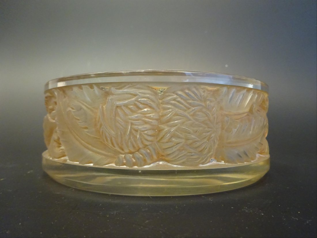 Objets de vitrine - Verrerie: Henri SAUMONT (actif XXe sicle) Vide-poche en verre press moul orn sur son pourtour d'une frise de feuilles de chne et de glands. Sign sur le pourtour. H: 4,5 cm - D: 13 cm