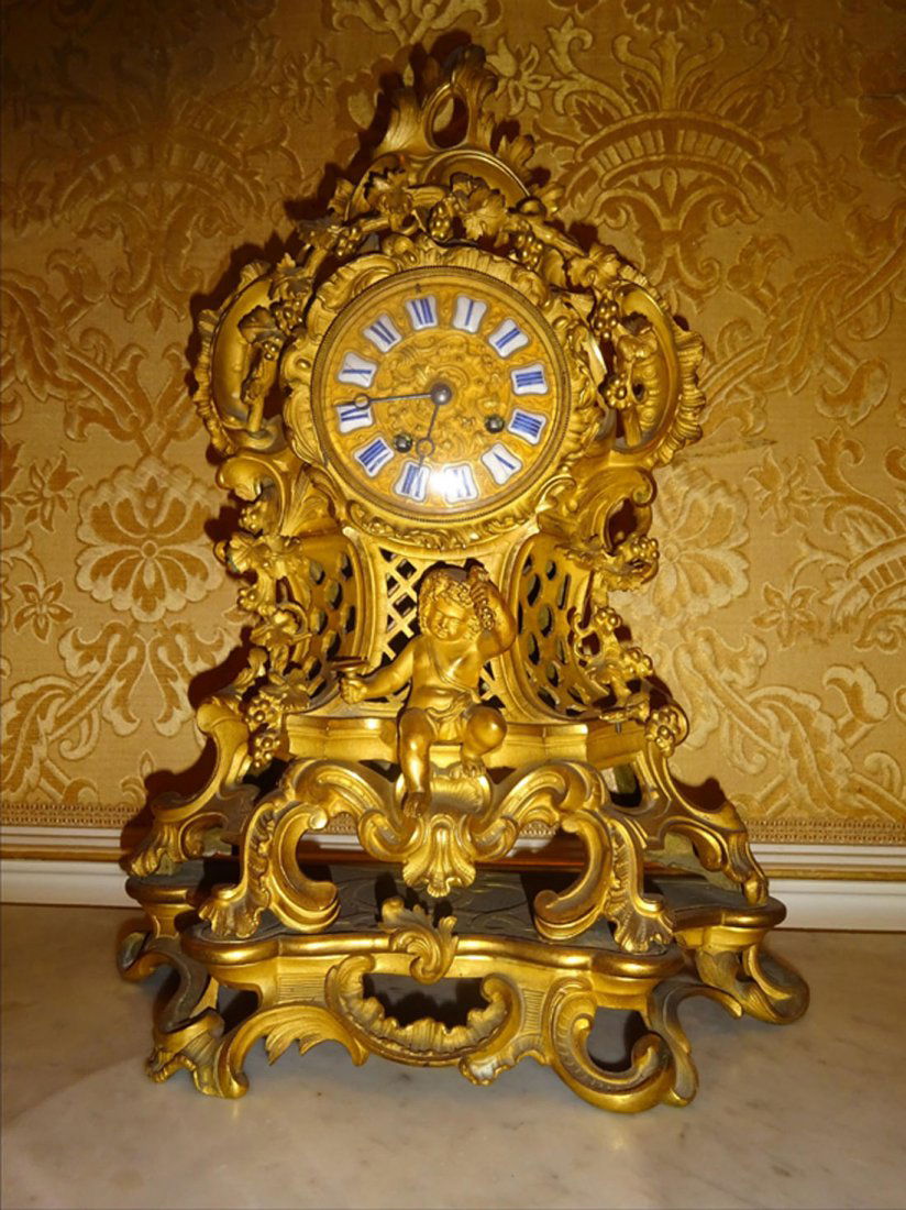 Objets d'Art: PENDULE en bronze cisel dor riche dcor de pampres de vignes et d'un jeune Bacchus. Le cadran dcor maill de chiffres romains dans des cartouches pour les heures. Vers 1900. H : 43 cm l : 30 cm