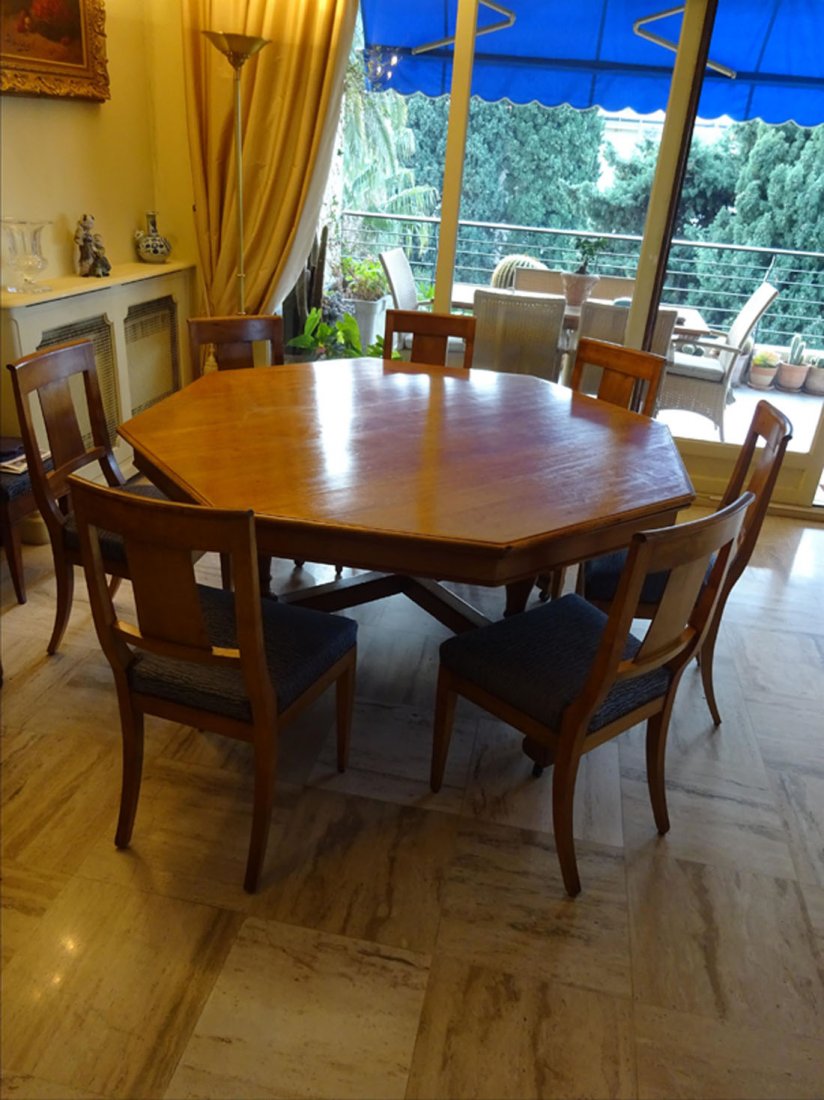 Mobilier Ancien: TABLE de salle manger en bois naturel plateau de section octogonale ; repose sur quatre montants balustres qu'achve un plateau d'entretoise pieds galbs support par des roulettes. On y joint: