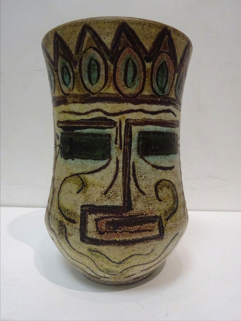 Design: ACCOLAY - Vase campaniforme carn en cramique dcor brun et vert sur fond ocre jaune de visages inspirs des Incas. Sign au dessous. Porte le numro 38 sur l'oreille gauche. H: 26 cm A FINE ACCOLAY 'IN