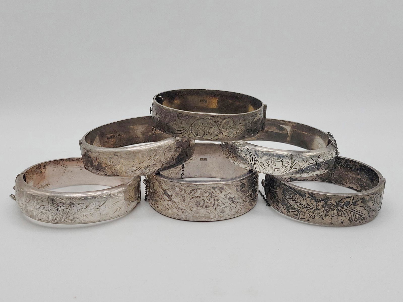 ENGLISH VICTORIAN; Six Engraved Sterling Silver Cuff Bracelets: All hallmarked, three with defective safety chains, 204 grams. Widths from 5/8" to 1".
