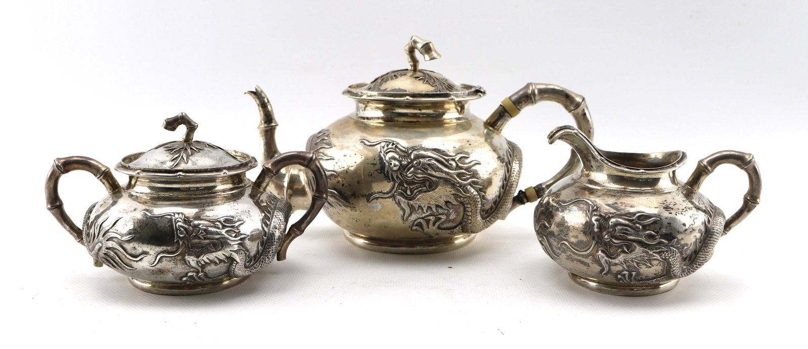 Wang Hing Chinese Export Silver Dragon Tea Set, 28.5 ozt: Condition good overall with the exception of the lower terminal of the teapot handle which has been crudely re-pinned with wire. Overall height of teapot appx. 5 inches.