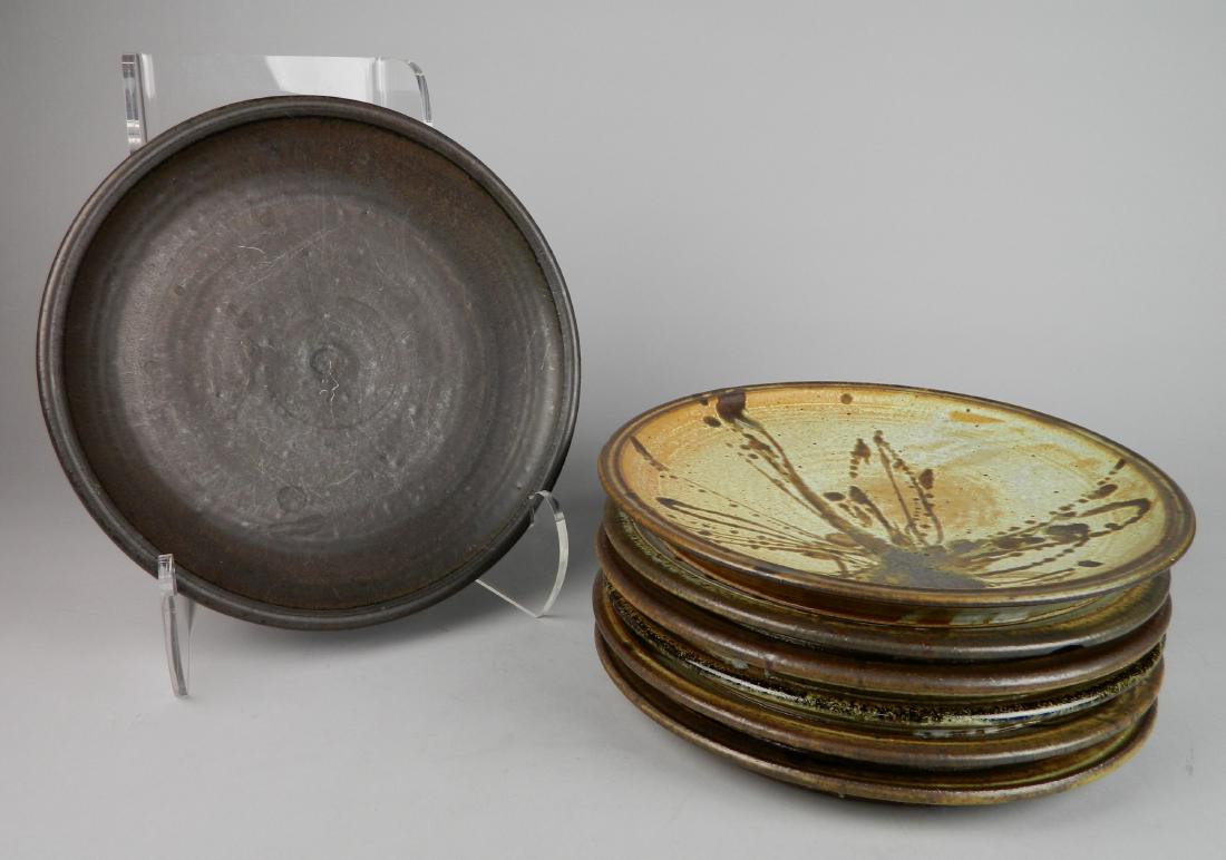 Jack Masson 7 ceramic plates: Jack Masson 7 ceramic plates- 6 of the same design, 2 of which have chips under rims; plus 1 brown plate, with scratches; all plates have artist's mark, all but the brown plate signed on bottom. 11''d