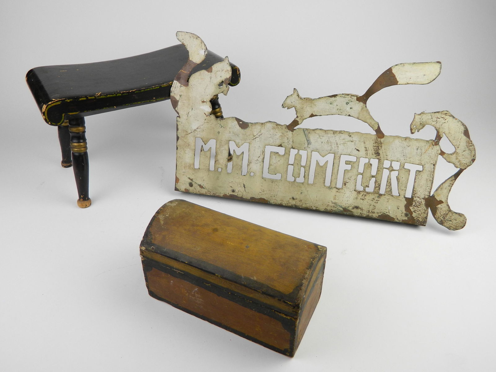 3 American folk art items: 3 American folk art items- including 1 small stool, 1 small trunk (lid detached), and a metal sign- ''M. M. Comfort''- overall fair condition.