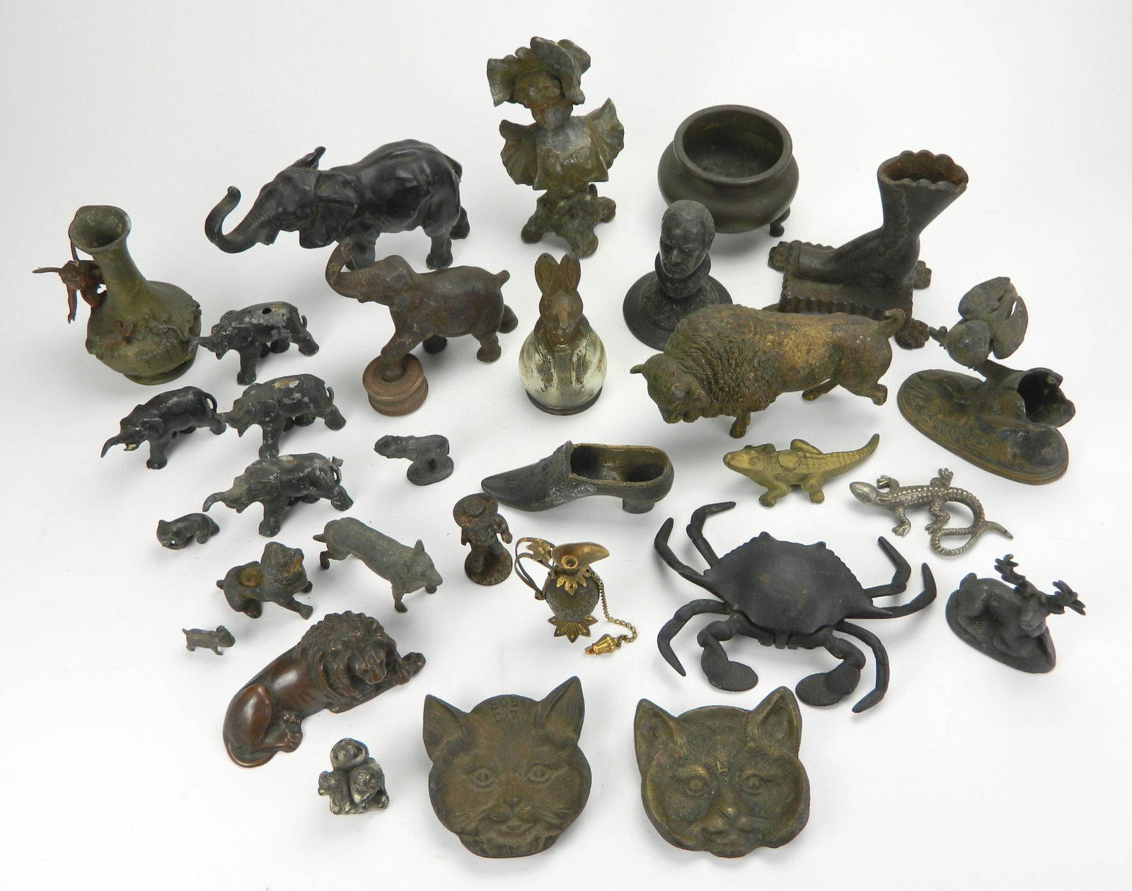 25+ cast iron and metal figurines: Lot of 25+ cast iron and metal figures including a perfume in the form of a decanter, 2 cat face ashtrays and one candy container- bunny form, various sizes, fair condition.