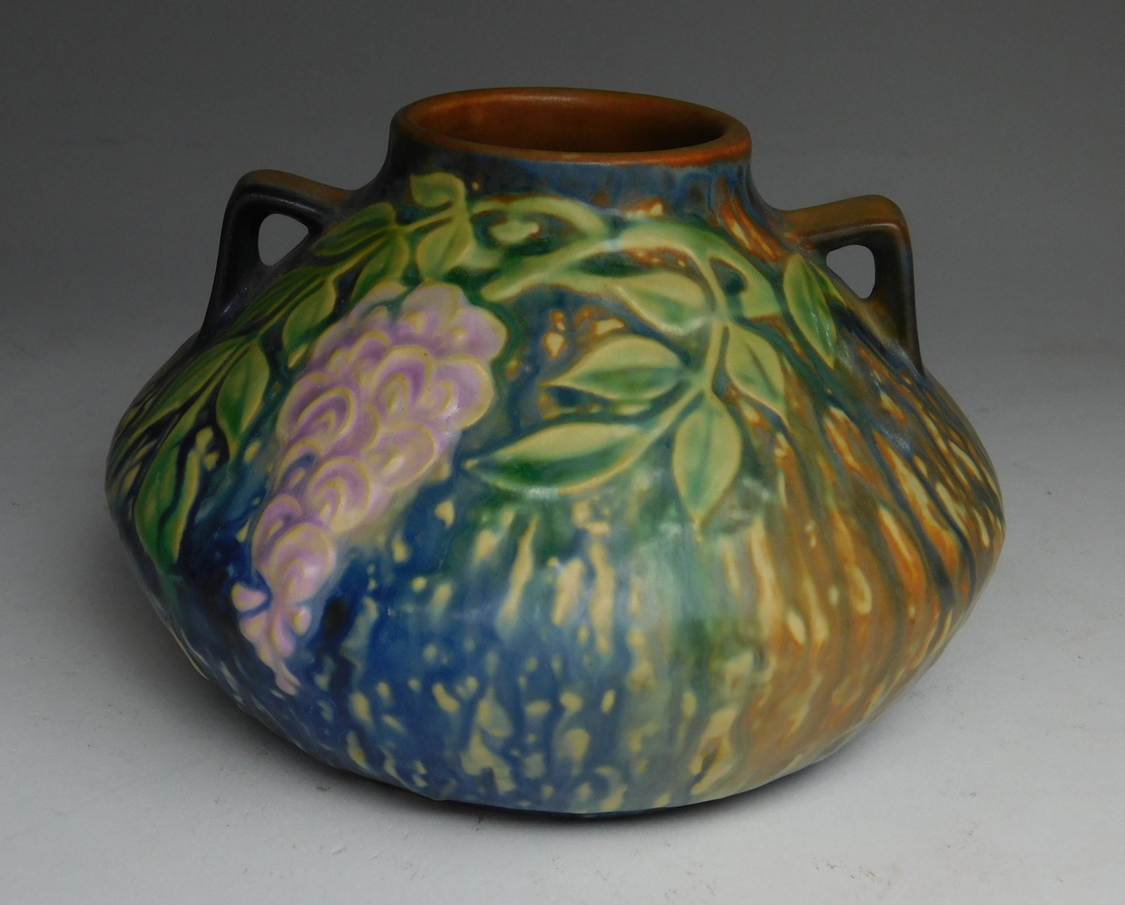 Roseville Wisteria pottery vase: Roseville Wisteria blue pottery vase with original foil sticker on bottom, good condition. 4 1/2''h
