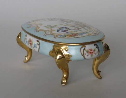H. Litkovitz hand-painted porcelain container: A hand-painted porcelain footed oval container with lid by Helen Litkovitz, depicting a scene of a peacock and bird on lid, on a light blue ground with applied gold, signed at lower right in scene on 