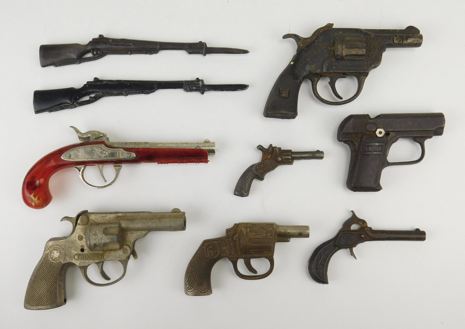 9 vintage toy guns: 9 Vintage toy guns- 7 cast iron, includes- Cadet pistol, 25 jr.; Imperial; Trooper, 2 rifles with bayonets and a Flintlock jr. all as is, worn from use.
