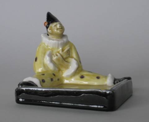 Rookwood Polychrome clown ashtray: Rookwood Polychrome clown ashtray, 1929- designed by Sallie Toohey covered in yellow, purple, black and orange, markes include the Rookwood logo, date and shape no. 6026, and artist's monogram. 4''h