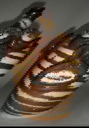 Billy Ray Hussey face jug: Billy Ray Hussey (American 1955- )- Face Jug- in 2 color swirl, slaw eyes, 8 top teeth and 10 bottom teeth, initialed 'B. H.' on bottom. 11''h