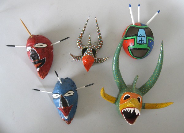 5 Masks: 5 Small masks- Miguel Caraballo- papier mache carnival mask; Luis Archilla- hand carved coconut mask; Loiza Vejigante- 2 carved coconut husk devil head masks; Juan Alindato- papier mache carnival mask