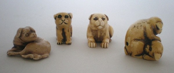 4 Netsukes: 4 Ivory Netsukes- Two Dogs Playing; Dog Curled; Dog Lying Down; and Small Dog- marked on bottom, good condition. 1''h. ea