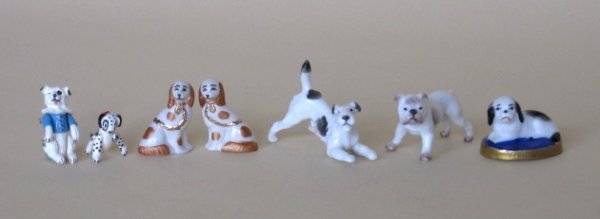 5 Miniature porcelain dogs and 2 other dogs: 5 Miniature porcelain dogs- a pair of Spaniels; Bulldog; Wire Hair Terrier; and another Dog on base; along with miniature pewter Dalmatian with 4 jointed legs; and another miniature dog with jointed l