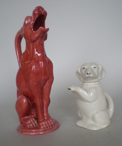 Burmantofts English Faience figural pitcher: Burmantofts English Faience figural pitcher- howling dog in soft red glaze, marked 'Burmantofts Faience' on bottom, repair at base; together with a figural ceramic pitcher of a begging dog. 13 1/2''h