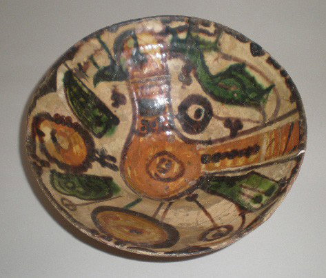 Persia Pottery Bowl: Persia Pottery Bowl- Amol, 9th c.- ivory glaze decorated in olive green brown and reddish brown colors with a large bird adn rosettes, several repairs. 3'' h x 7 1/2'' dia