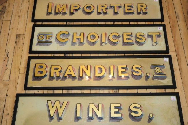19th c. Advertising panels- wines: 4 19th c. glass advertising panels, reverse painted glass- ''Importers/ of Choicest/ Brandies &/ Wines &'', some chips at edges, wear. 2- 7 1/2 x 36''; 2- 7 1/2 x 35''