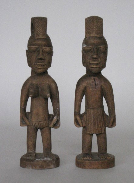 Pair of Yoruba Nigeria Figures: Pair of Yoruba Nigeria Figures- wood, tailed, looped, hairstyle curves from back of head above skull to forehead, closed eyes, male has small surface crack on chest. 12 1/2''
