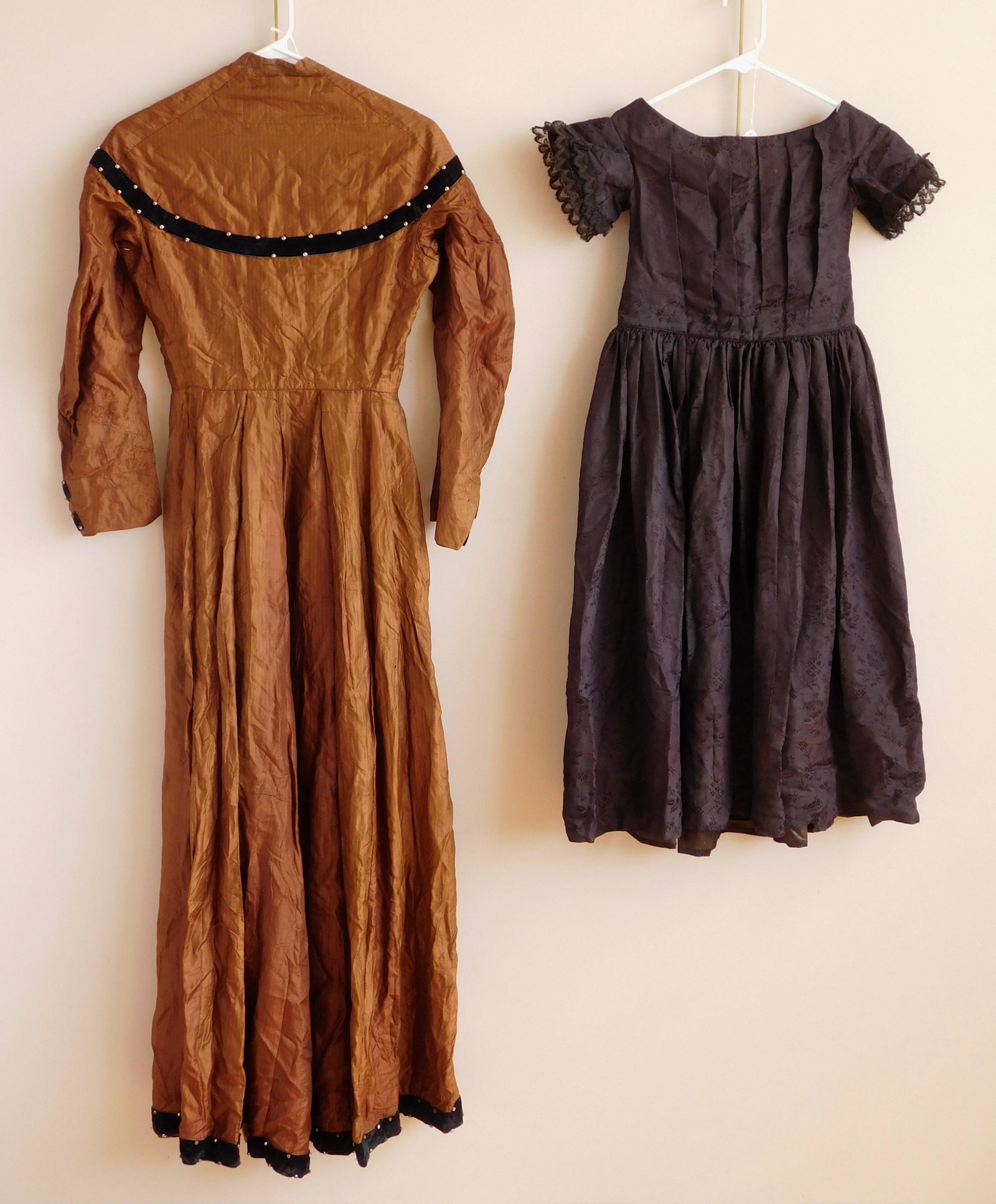 2 Dresses: 2 Dresses 1). Silk youth black short sleeve dress, c. 1840-50, some staining. bust 24'', waist 26'', sleeve length 4'', skirt length 26 1/2''; along with 2). An adult silk brown dress. bust 34'', wais
