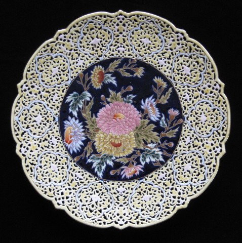 Zsolnay porcelain reticulated charger: Zsolnay porcelain reticulated charger, central medallion with colorful flora design on a deep blue field, wide rim in soft gold, marked on back, very good condition. 15 1/2'' dia.