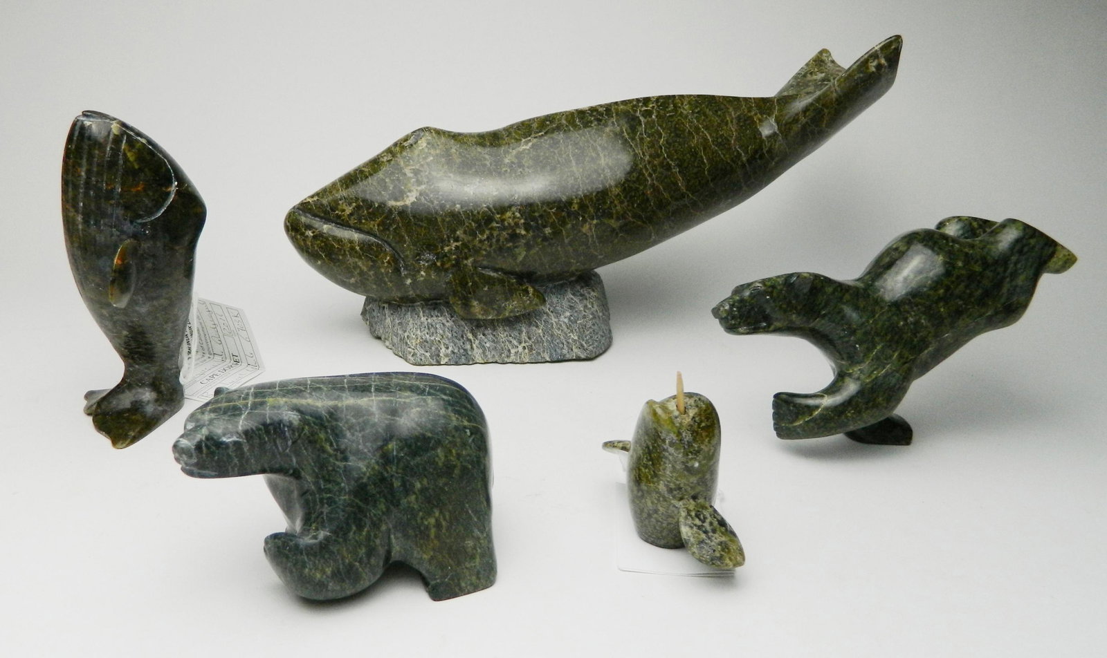5 Inuit stone carvings: 5 Inuit stone carvings 1). Ohito Ashoona / Cape Dorset- Whale- signed. 6 1/2 x 11 x 3 1/4''; 2). King- Polar Bear- signed. 2 1/2''; 3 & 4). Nungusaitole Qajurajul / Cape Dorset- Narwhal. 2''h; and Bow