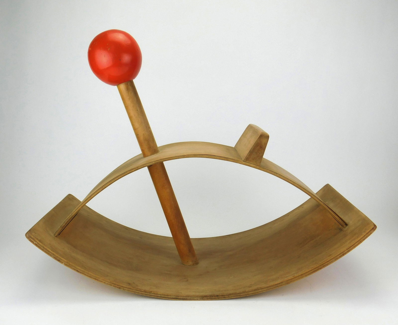 Creative Playthings rocker.: Molded plywood child's rocker by Creative Playthings with a red ball handle, 1965, designed by Gloria Caranica (20th c.), signed. 16'' x 11 3/4 x 25 3/4''
