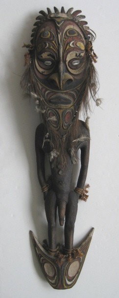 New Guinea carved male figure: New Guinea carved male figure, wood, paint, cowries shells and feathers. 46''l
