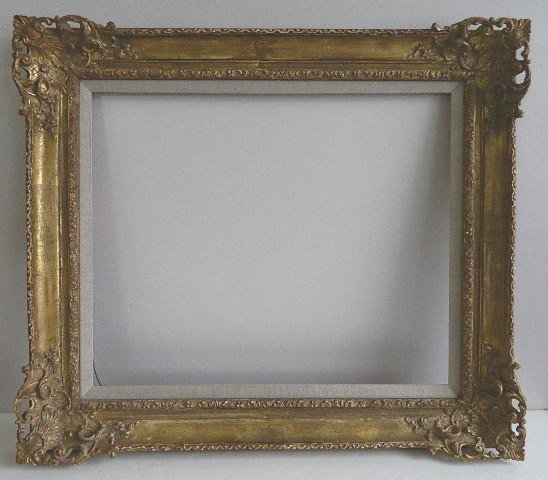 Gilded mould made frame: Gilded mould made frame with openwork shell flourishes at the corner, beige linen liner, one area of loss exposing plaster, otherwise good condition. int 28 1/4 x 23'' ext 38 1/4 x 22 3/4 x 3 1/4''