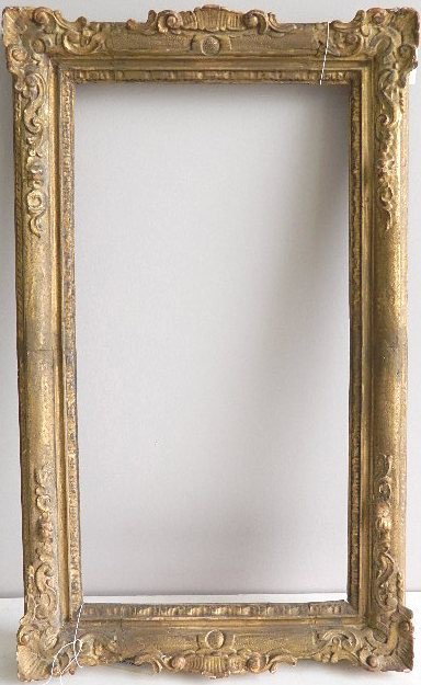 Hand carved gilded frame: Hand carved gilded frame, with floral scroll motif, cut down from original size, visible seams loss to gilding. int 27 5/8 x 14 1/4'' ext 34 x 21 x 3 1/2''