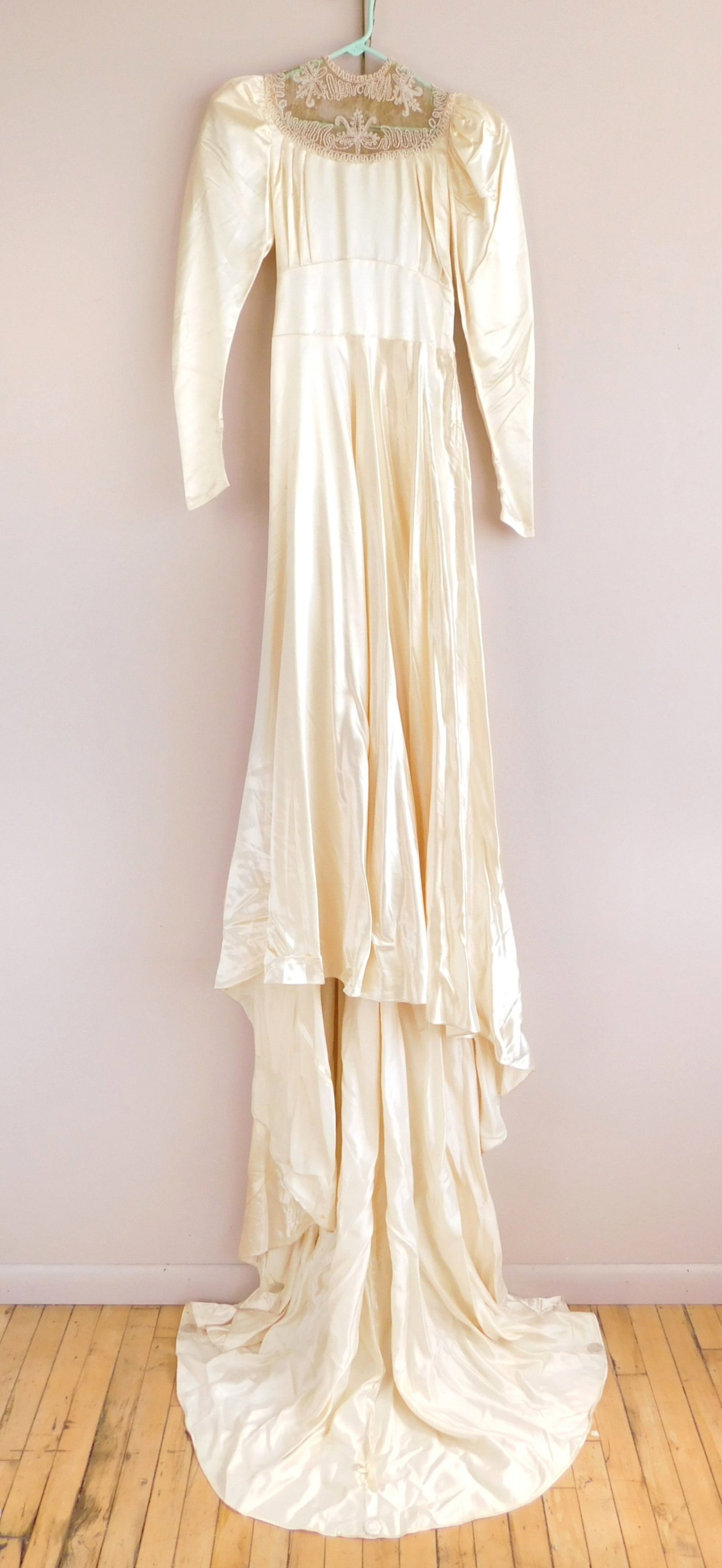 Vintage satin wedding dress: ivory/ champagne with beadwork in upper bodice and puffy long sleeves, along with snap button closures (4) on back of upper bodice and along wrist (6), zipper closure on side. Bust- 34"; Wa