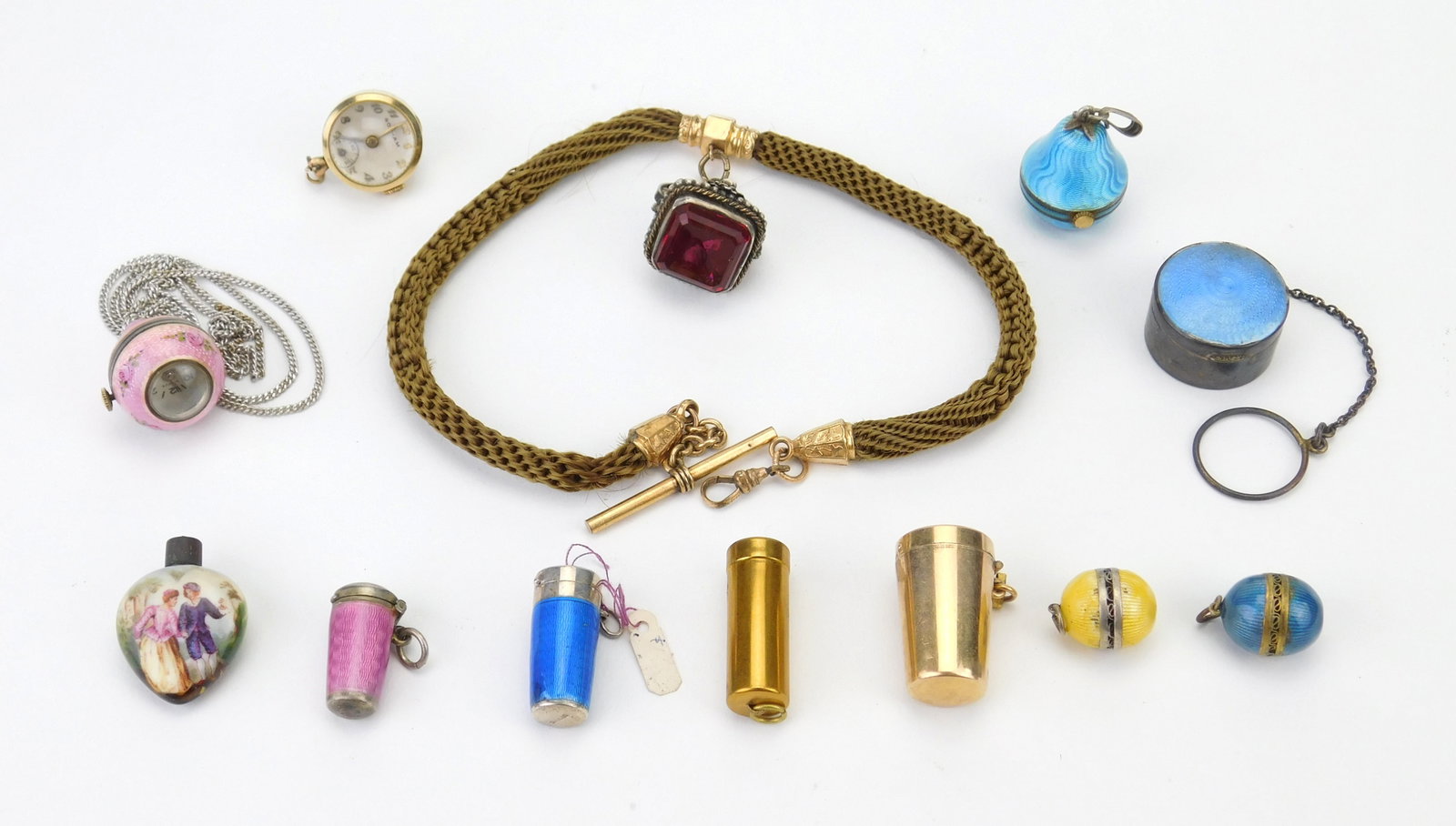 12 Vintage Ladies accessories: 7 guilloche enamel pendants, 2 brass collapsible cigarette holders, heart shpae perfume bottle with a hand-painted scene of a courting couple; Gotham watch pendant and a costume pendant with red