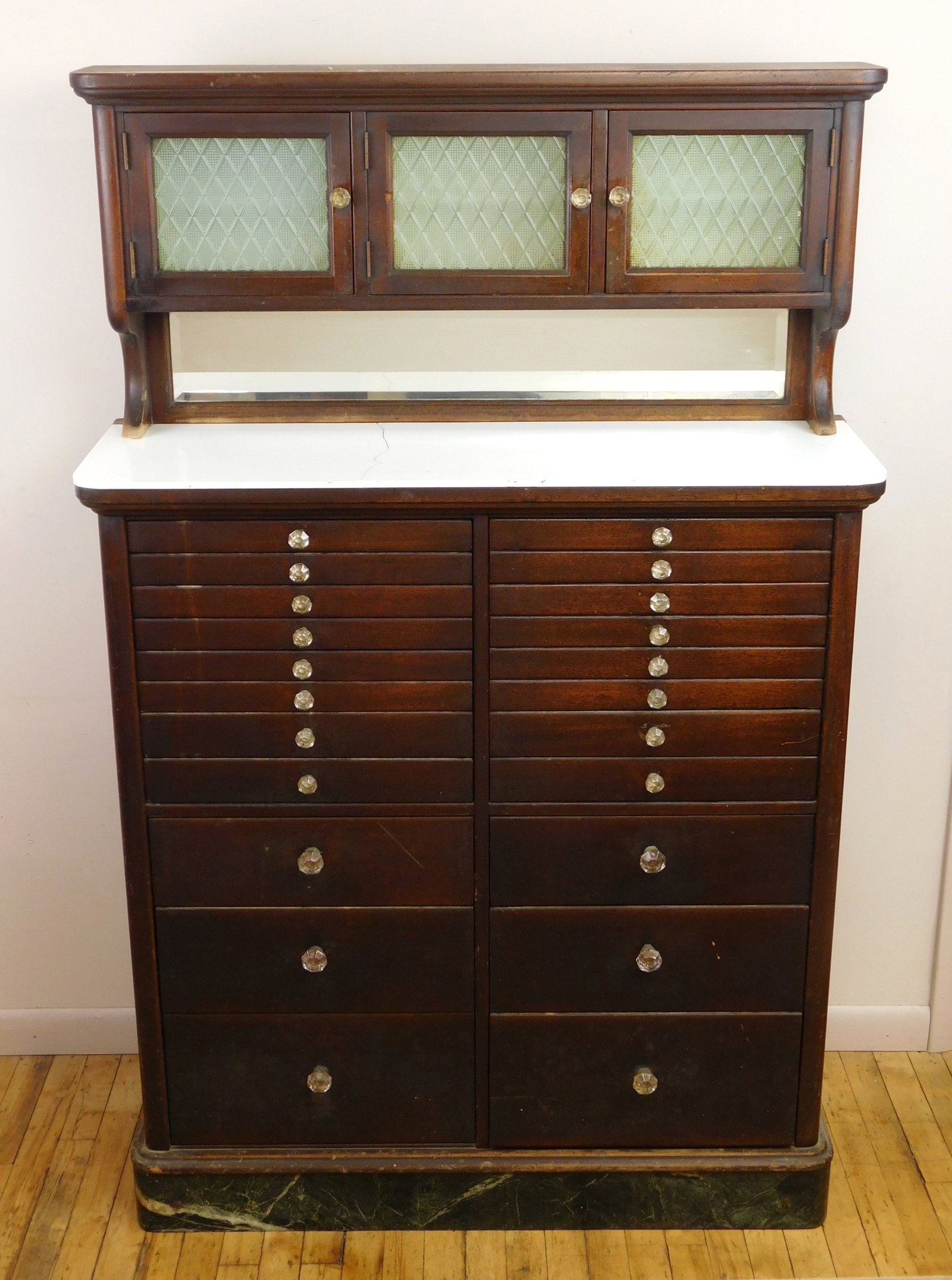 1920's Mahogany dental cabinet: with 22 drawers, milk glass interior in 3 upper cabinet, beveled mirror, with several milk glass dental trays, marble top. 62 3/4 x 40 x 13 1/4" Provenance: Private collec