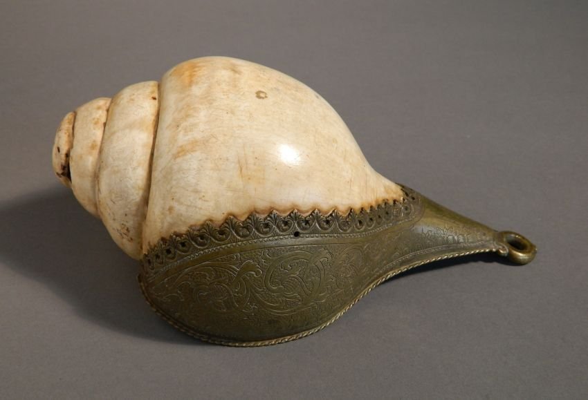 18th c. Singhalese conch shell: 18th c. Singhalese conch shell with brass mounts, wear throughout, minor chipping. 9 x 4 1/2 x 3 3/4''
