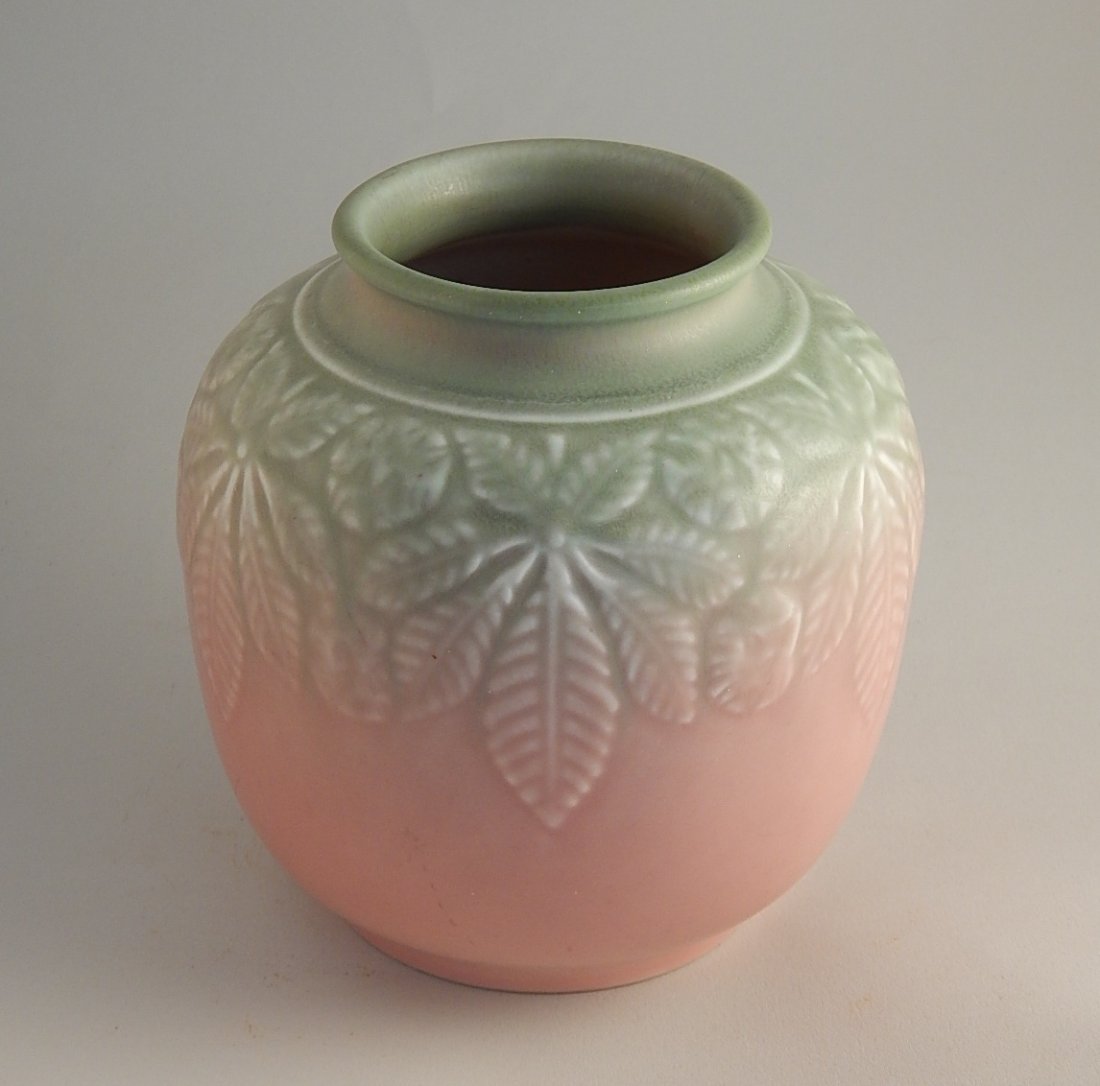 Rookwood pottery production vase: Rookwood pottery production vase, 1939, bulbous form with raised buckeye design covered in a soft green to pink mat glaze, marks include the Rookwood logo, date and shape number 6632. 5''h