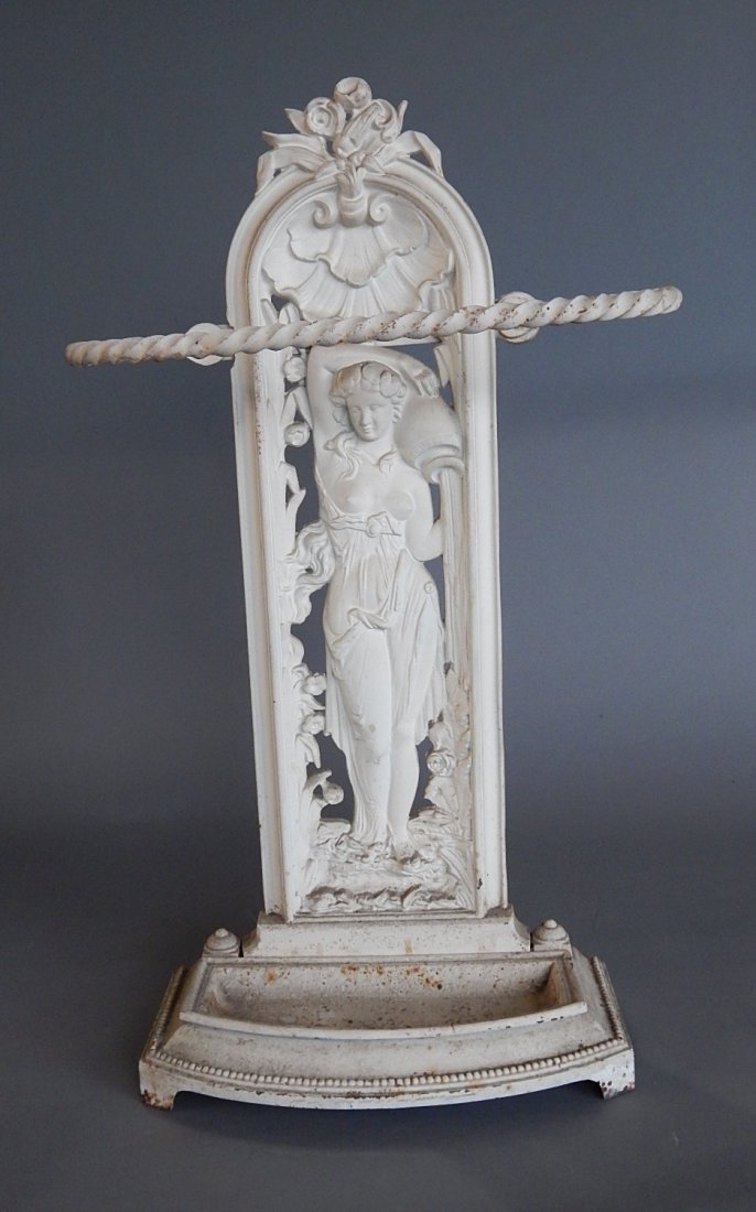 Cast iron figural umbrella/cane rack: Cast iron figural umbrella/cane rack- ''Rebecca at the Well'' back panel, wear throughout. 16 1/2 x 6 x 28 1/2''