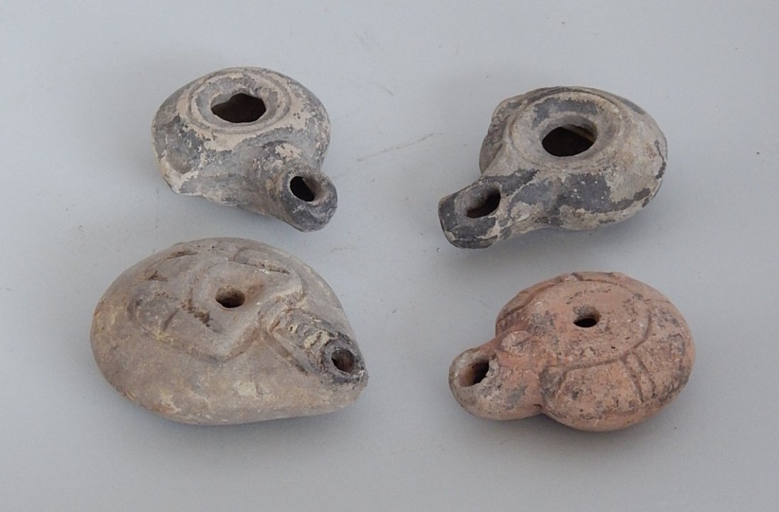 4 Roman earthenware oil lamps: 4 Roman earthenware oil lamps. largest 3 1/8'' across