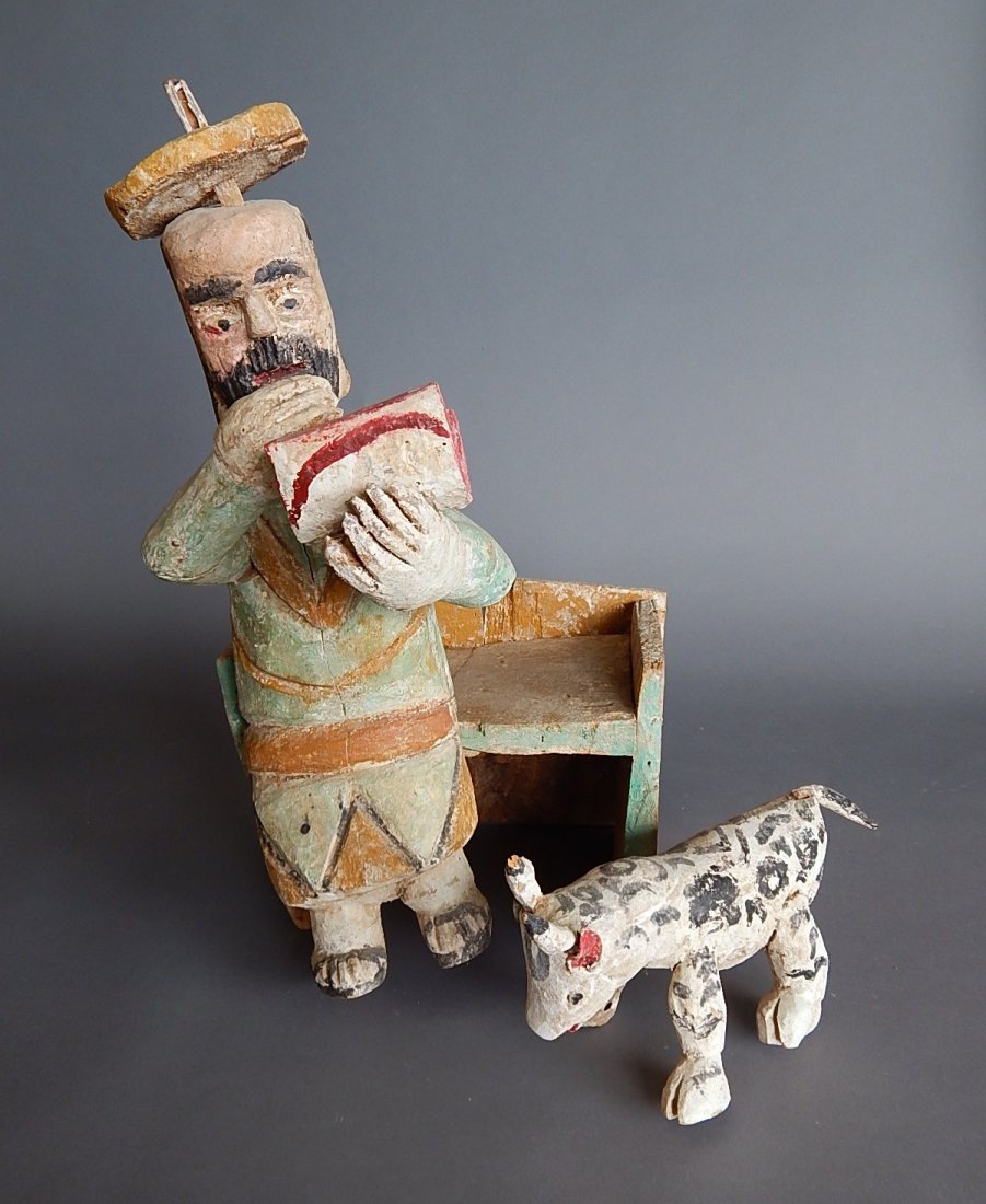 Mexican carved and painted statue: 20th c. Mexican carved and painted wood statue- Seated Man with an Animal, some wear. 22''h