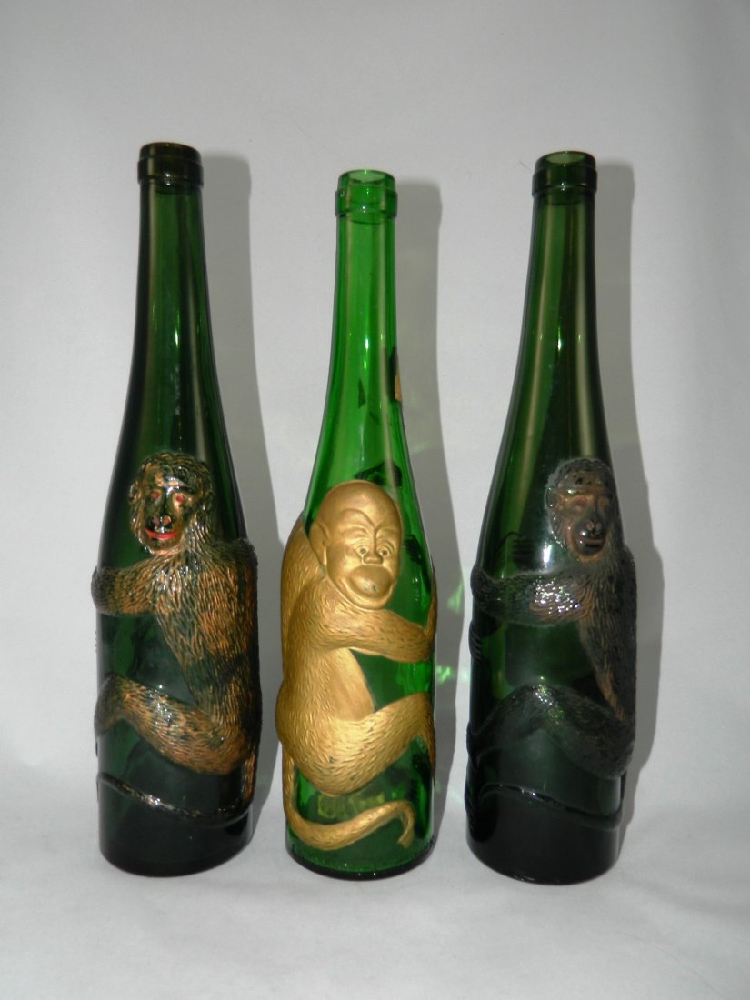 Wine - 3 green round bottles: Wine- 3 green, round, embossed with monkey wrapped around bottle, painted in gold, some loss in gold decoration. 13 1/2''h; 13''h