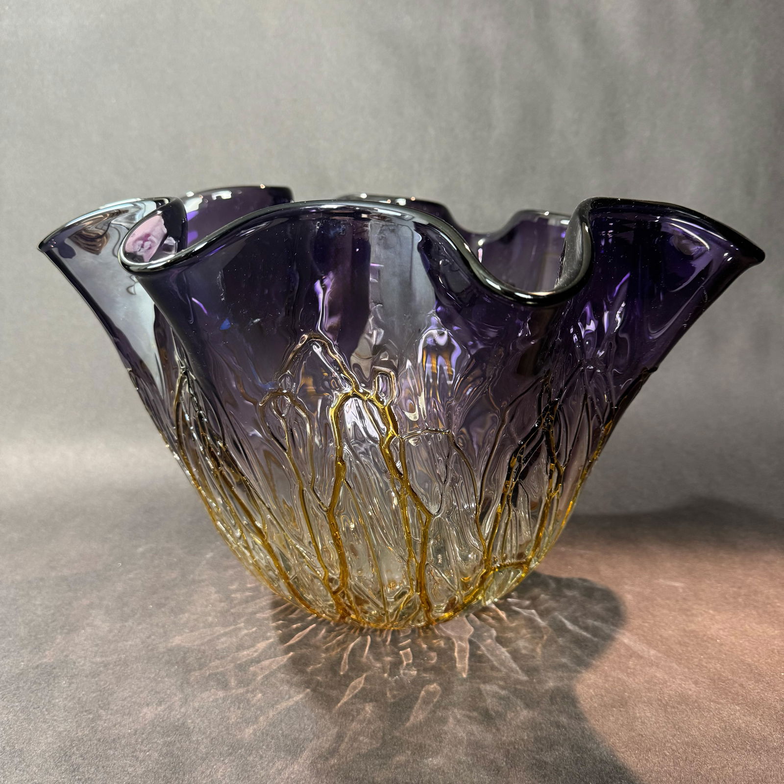 10" Purple/Gold Vineland Bowl: Title: 10" Purple Vineland Glass Bowl Medium: Hand-rolled Glass Size: 10 H x 15.5 W x 15.5 D Weight: 8.9 lbs. This glass bowl is a stunning display of glass artistry, with rich gradients of amethyst m