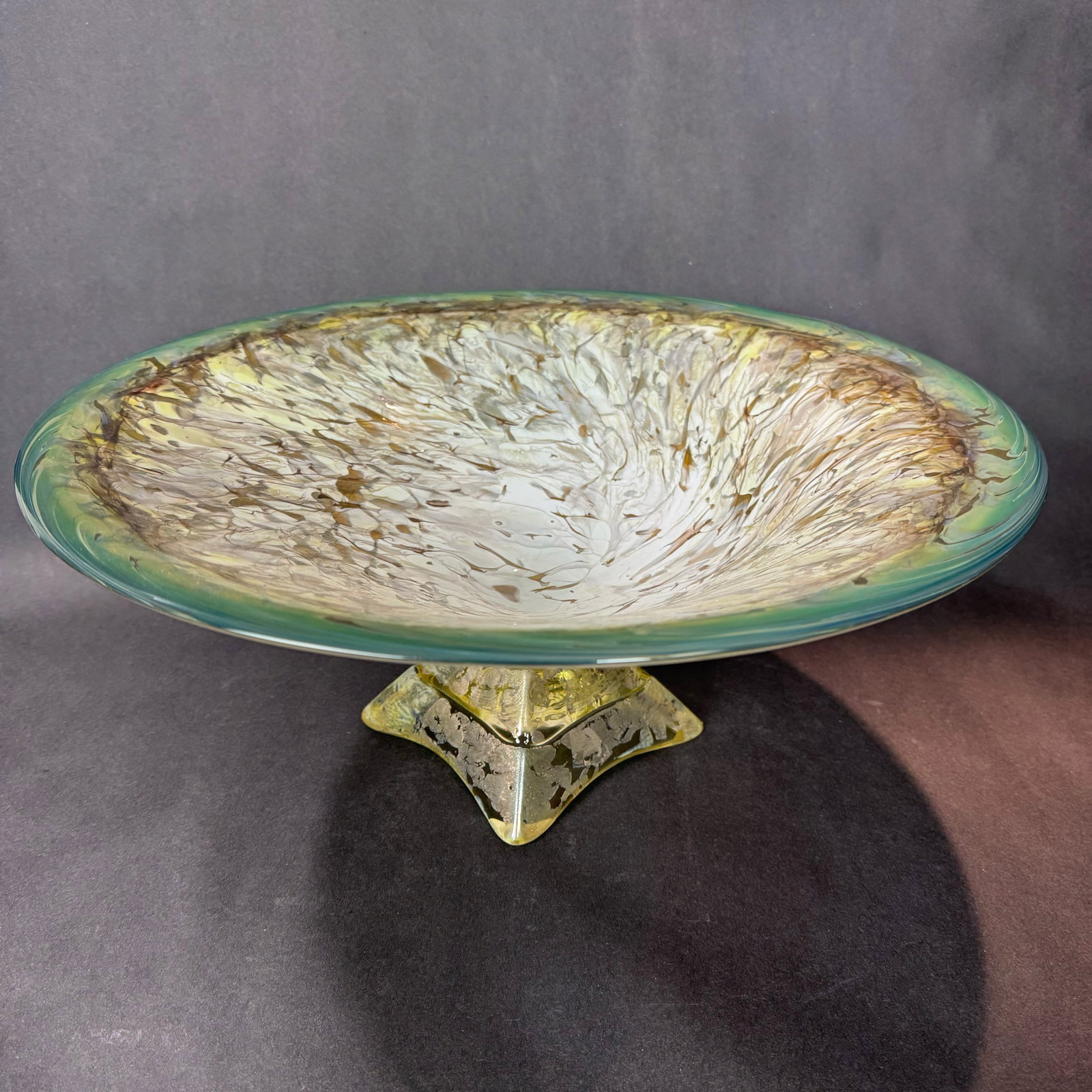 Willsea & O'Brian 7.25" H x 17" W Jade & Gold Bowl: Artist: Willsea & O'Brian Title: Jade & Gold Bowl Medium: Glass Size: 7.25" H x 17" W x 17" D Weight: 6.6 lbs. Edition: Unique This elegant art glass bowl blends sculptural form with organi